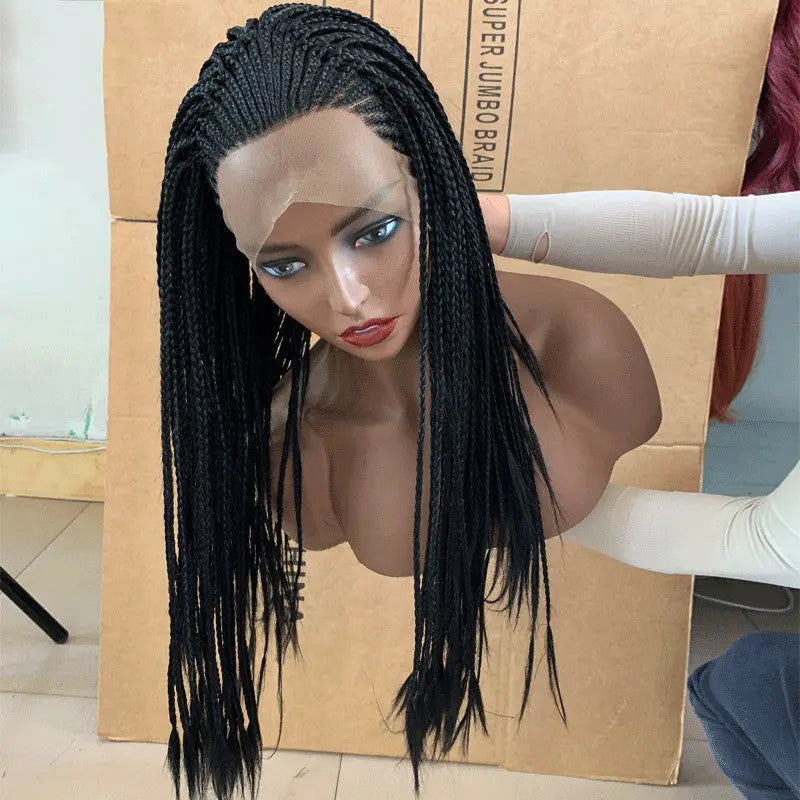 Synthetic lace front wig with long black braids, displayed on mannequin head. Gloved hands adjusting wig. Cardboard box in background.